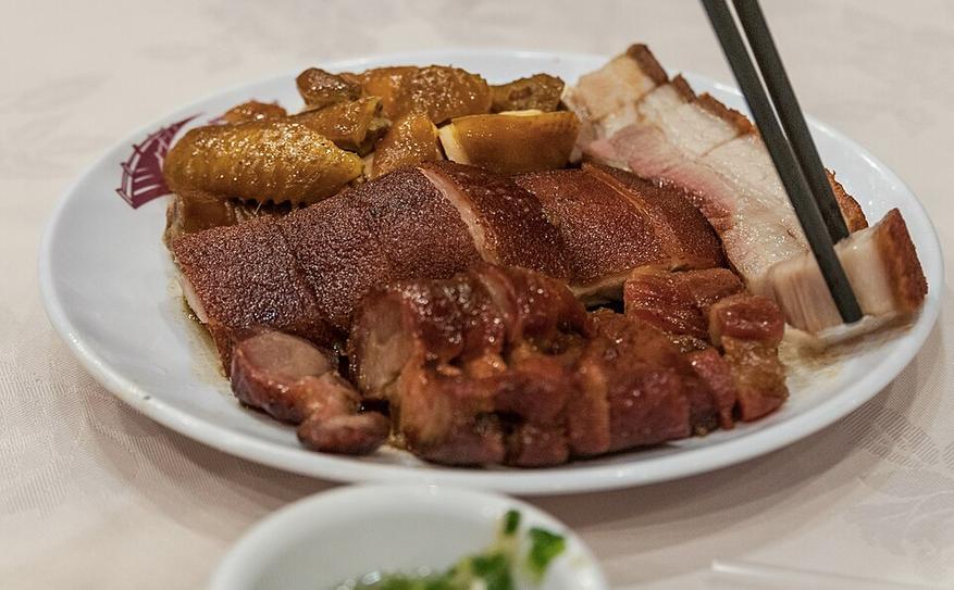 На одной тарелке показаны чар сиу, хрустящая свинина siu yuk и курица в соевом соусе.